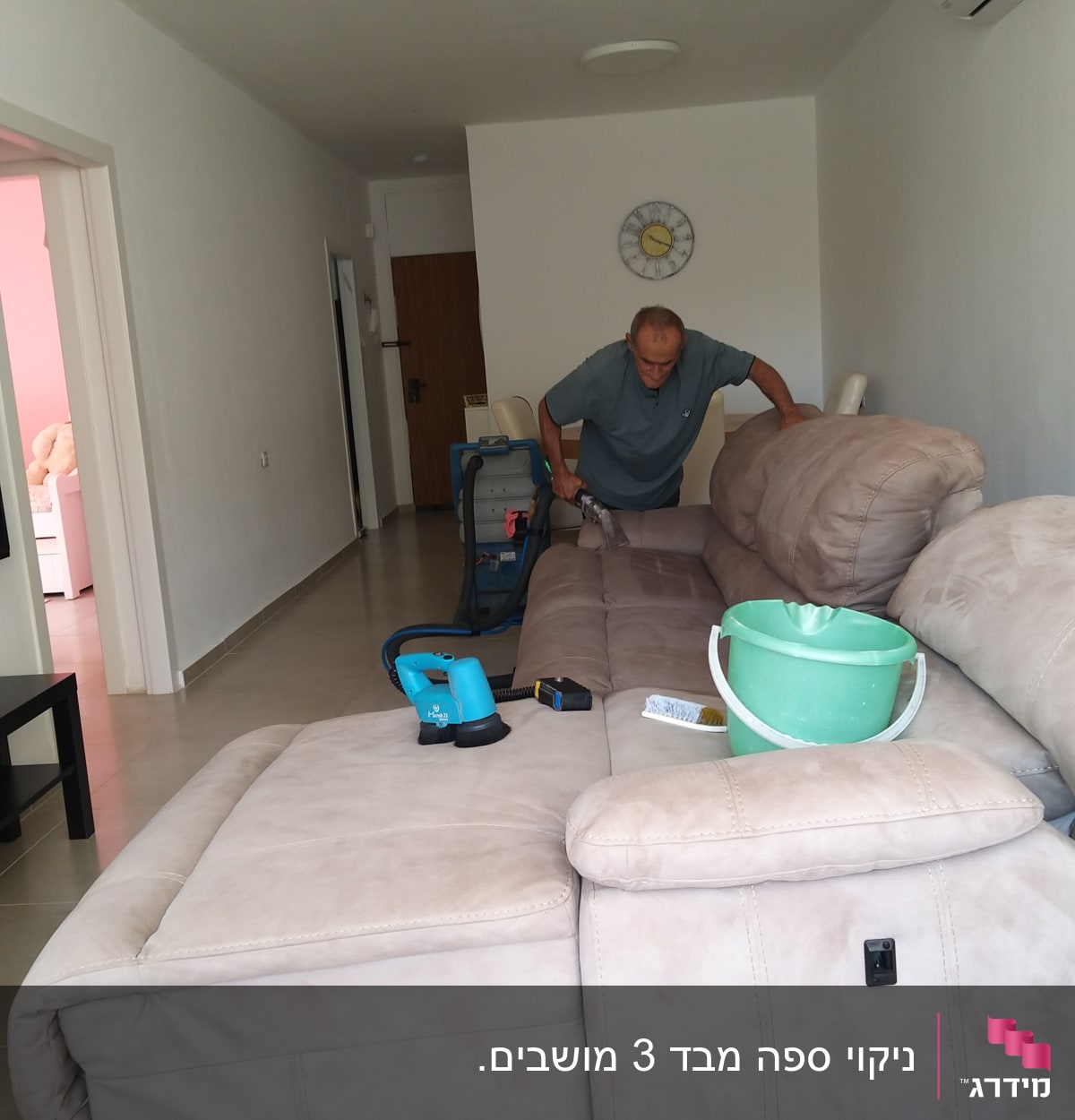 אדם מנקה ספה עם שואב אבק ודלי ירוק